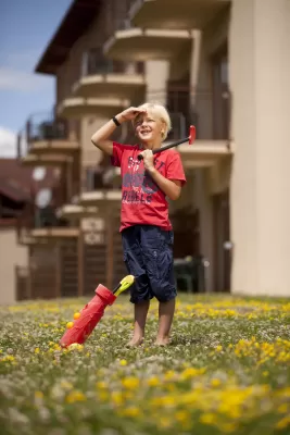 Krainz Vital & Familienhotel - Bad Loipersdorf: Kind mit Golfschlägern vor dem Familien Hotel